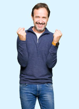 Orta yaş yakışıklı adamın bir kazak kutluyor giydiğini şaşırttı ve silah ile başarı için yükseltilmiş ve açık gözler hayrete düşürdü. Kazanan kavramı.