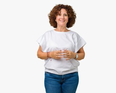 Arka plan eller üzerinde beyaz t-shirt giyen güzel orta ager üst düzey kadın birlikte izole ve rahat ve neşeli gülümseyen parmak çarpı işareti. Başarı ve iyimser