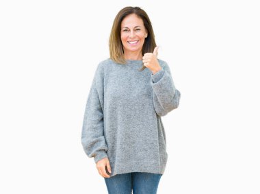 Hareketi el ile mutlu yaşasın yapıyor izole arka plan üzerinde kış kazak giyen güzel orta yaş kadın. Başarı gösteren kameraya bakarak ifade onaylama.