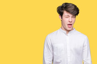 Genç yakışıklı iş adamı seksi bir ifadeyle, neşeli ve mutlu yüzünü kameraya bakarak göz kırpıyor izole arka plan üzerinde.