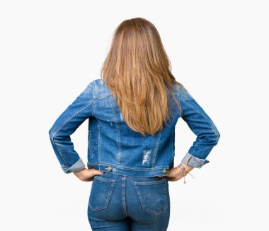 İzole arka plan ayakta geriye doğru uzakta silah ile vücut üzerinde seyir üzerinde rahat denim ceket giyen güzel orta yaş kadın