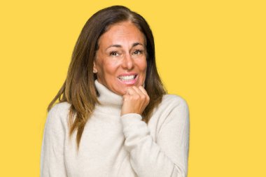 Stresli ve gergin elle çivi ısırma ağzına bakarak izole arka plan üzerinde kış kazak giyen güzel orta yaş yetişkin kadın. Anksiyete sorunu.