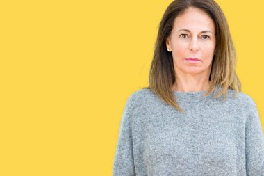 Üzerinde kış kazak giyen güzel orta yaş kadın arka plan gevşek yüzünde ciddi bir ifade ile izole. Basit ve doğal kameraya bakıyor.