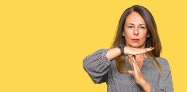 Güzel orta yaş iş kadını yapıyor zaman aşımı jest elle, sinirli ve ciddi bir yüz