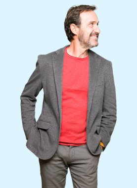 Orta yaş yakışıklı iş adamı uzak tarafına yüzünde, doğal ifade gülümseme ile arıyorum. Kendine güvenen gülüyor.