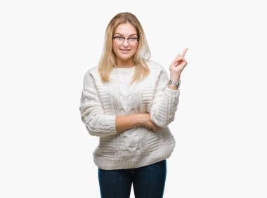 Kameraya bakarak yan el ve parmak ile işaret yüzünde kocaman bir gülümseme ile izole arka plan üzerinde gözlük takan genç kafkas kadın.