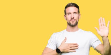 Bir sadakat sözü yemin yapma rahat beyaz t-shirt Swearing göğüs ve avuç, el ile giyen yakışıklı adam