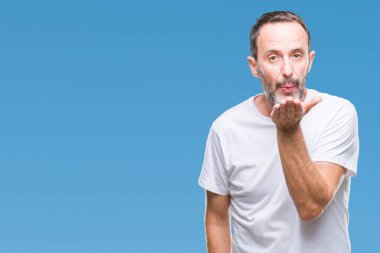 Bir öpücük el ile güzel ve seksi olmak hava üfleme kamera bakarak izole arka plan üzerinde beyaz t-shirt giyen orta yaş ağarmış komuta sizde. Aşk ifade.