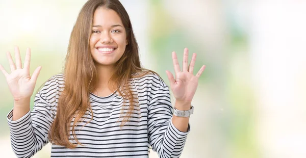 分離背景表示と指で上向きに若い美しいブルネットの女性着用のストライプ セーターは自信を持って 幸せな笑みを浮かべている間 数します — ストック写真