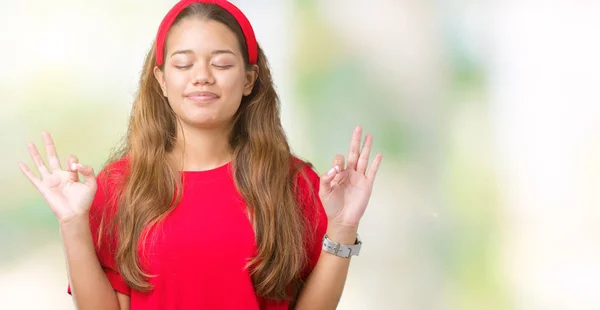 年轻美丽的黑发女人穿着红色的 T恤在孤立的背景放松和微笑闭着眼睛做冥想手势用手指 瑜伽概念 — 图库照片