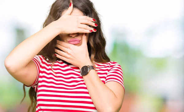 Gözlük kapsayan gözler ve ağız el ile giyen genç güzel kadın şaşırttı ve şok. Duygu gizleme