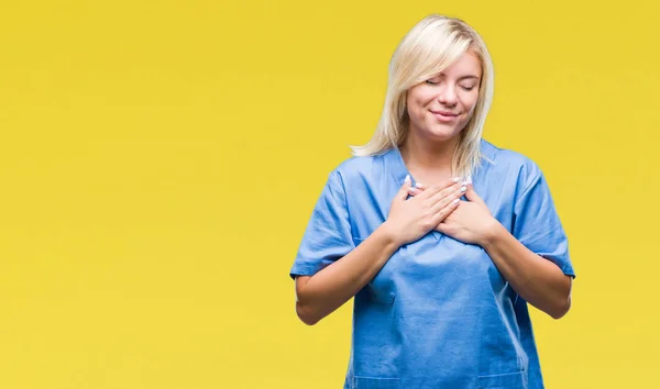 以上の美しいブロンドの看護師医師女性は 目を閉じて胸に手と顔に感謝のジェスチャーと笑顔の背景を分離しました 健康の概念 — ストック写真