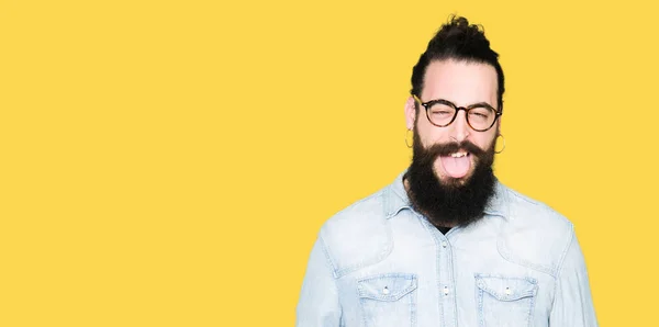 Hipster Młody Człowiek Długimi Włosami Brodą Okularach Trzymanie Języka Out — Zdjęcie stockowe