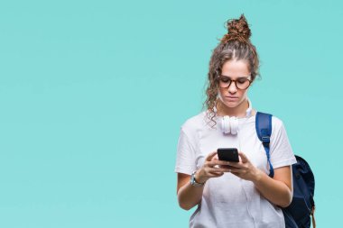 Sırt çantası, kulaklık ve smartphone acımak yüz ciddi düşünüyorum üstünde kendine güvenen bir ifade ile izole arka plan üzerinde giyen genç esmer öğrenci kız