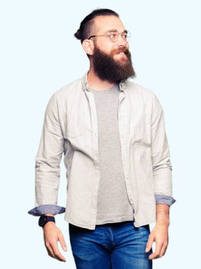 Genç sarışın adam gözlüklü görünümlü yan ve dik dik bakma uzağa düşünce gülümseyen.