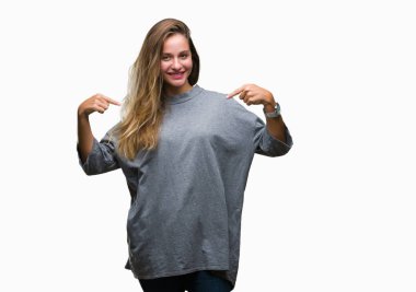 Yüzünde gülümseme ile kendinden emin görünüyorsun, kendini gururlu ve mutlu parmakları ile işaret izole arka plan genç güzel sarışın kadın.