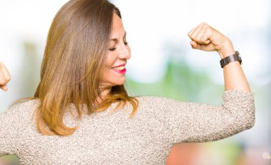 Moda kazak gösteren kol kasları gururlu gülümseyen giyen güzel orta yaş kadın. Fitness kavramı.