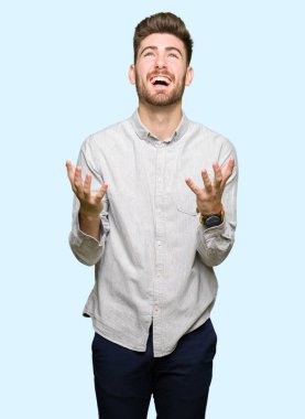 Genç, yakışıklı bir adam, sıradan bir gömlek giyiyor. Deli gibi bağırıyor, agresif bir ifadeyle bağırıyor ve kollarını kaldırıyor. hüsran kavramı.