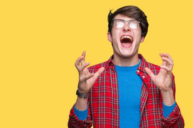 Üzerinde gözlük takan genç yakışıklı öğrenci adam arka plan deli izole ve deli bağırarak ve agresif ifade ve silah kaldırdı bağırıyor. Hayal kırıklığı kavramı.