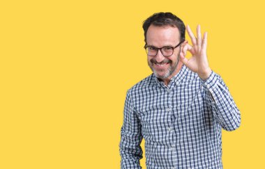 Yakışıklı orta yaş zarif üst düzey iş adamı izole arka plan el ve parmaklar ok işaretiyle yapıyor olumlu gülümseyen üzerinde gözlük takıyorum. Başarılı ifade.