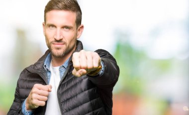 Yakışıklı adam kış ceket savaşmak için kum yumruk, saldırgan ve kızgın saldırı, tehdit ve şiddet