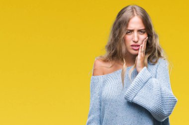 Diş ağrısı veya dişlerde dişlerle ilgili hastalık nedeniyle ağız acı ifadesi ile el ile dokunmak izole arka plan üzerinde kış kazak giyen güzel genç sarışın kadın. Diş hekimi kavramı.