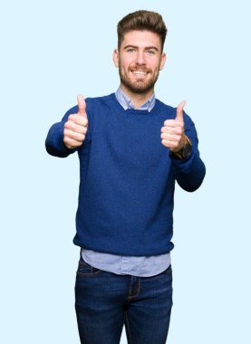 Genç yakışıklı bussines adam el ile pozitif jest yapıyor onaylama başparmak gülümseyen ve başarı için mutlu. Kamera, kazanan jest arıyorsunuz.