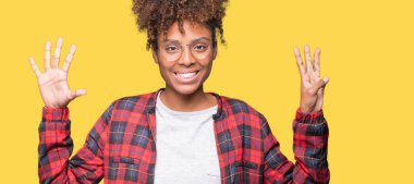 Güzel genç Afro-Amerikan kadın gözlük gösterilen ve parmakları ile işaret izole arka plan üzerinde kendinden emin ve mutlu gülümseyerek süre sekiz numara.