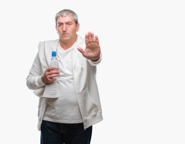 Yakışıklı komuta sizde eğitim holding havlu ve su şişe açık eliyle dur işareti ile ciddi ve kendine güvenen ifade, savunma jest yapıyor izole arka plan üzerinde