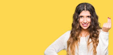 Kendine güvenen ifade el ve parmak ile İtalyan jest yapıyor beyaz kazak giyen genç güzel kadın