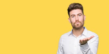 Genç yakışıklı iş adamı bir öpücük el ile güzel ve seksi olmak hava üfleme kamera bakıyor. Aşk ifade.