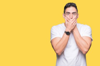 Üzerinde rahat beyaz t-shirt giyen genç adam arka plan ağız hata için elleriyle kapsayan şok izole. Gizli kavramı.
