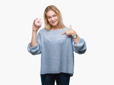 Sürpriz yüz işaret parmağı kendini izole arka plan üzerinde tatlı çörek yiyen genç kafkas kadın