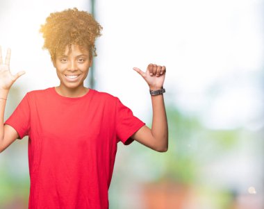 Güzel genç Afro-Amerikan kadın gösterilen ve parmakları ile işaret izole arka plan yüzünden kendinden emin ve mutlu gülümseyerek süre 6 numara.