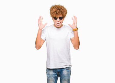 Kızgın ve silah ile başarı için deli kutluyor güneş gözlüğü takıyor afro saçlı yakışıklı delikanlı kaldırdı ve heyecanlı çığlık gözler kapalı. Kazanan kavramı