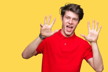 Yakışıklı delikanlı gösterilen ve parmakları ile işaret izole arka plan üzerinde kırmızı t-shirt giyen numara 9 kendinden emin ve mutlu gülümseyerek süre.