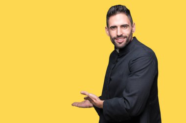 Genç Hıristiyan rahip izole arka plan açık el ile doğal gülümseyen girmek için davet üzerine