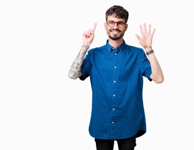 Gösterilen arka plan üzerinde gözlük takan genç yakışıklı adam izole ve parmakları ile işaret kendinden emin ve mutlu gülümseyerek süre 6 numara.