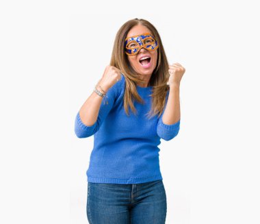 Üzerine Venedik karnaval maskesi giyen güzel orta yaş kadın gülümseyerek ve başarı için çığlık arka plan çok mutlu ve heyecanlı kaldırdı, silah ile kazanan jest yapıyor izole. Kutlama kavramı.