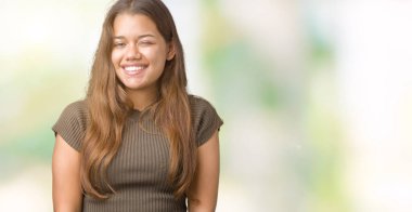 Genç güzel esmer kadın seksi bir ifadeyle, neşeli ve mutlu yüzünü kameraya bakarak göz kırpıyor izole arka plan üzerinde.