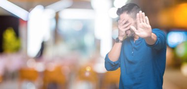 Genç yakışıklı adam izole elleriyle gözlerini kapsayan arka plan ve stop jest ile acı ve korku ifadesi. Utandım ve negatif kavramı.