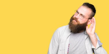 Genç sarışın adam gözlük ile gülümseyen bir işitme söylenti ya da dedikodu için dinleme kulak teslim. Sağırlık kavramı.