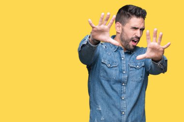 Genç yakışıklı adam şokta bağırarak korkuyor ve dehşet korku ifade dur hareketi el ile ile izole arka plan üzerinde. Panik kavramı.