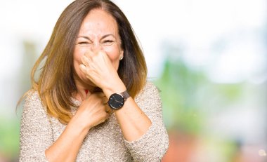 Bir şey pis ve iğrenç kokulu moda kazak, dayanılmaz koku, holding nefes parmak ile burun üzerinde giyen güzel orta yaş kadın. Kötü kokuyor kavramı.