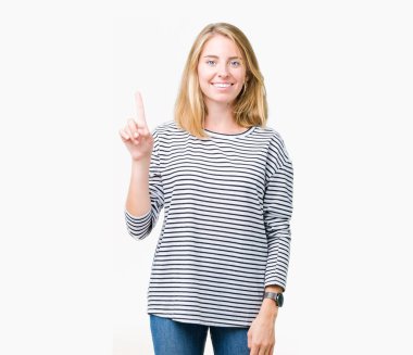 Ve parmak gülümseyen süre bir numara ile kendinden emin ve mutlu yukarıyı gösteren izole arka plan üzerinde çizgili süveter giyen güzel genç kadın.