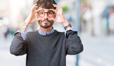 Genç yakışıklı parmaklarıyla, Uykulu ve sabah yorgunluk için yorgun gözlerini açmaya çalışırken izole arka plan üzerinde gözlük takan adam akıllı