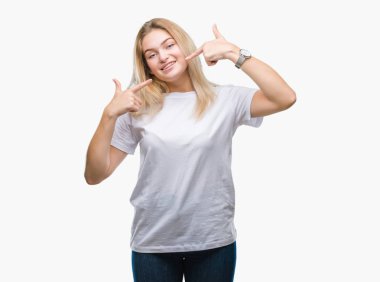 Kendinden emin gösterilen ve işaret parmakları diş ve ağız ile gülümseyen izole arka plan üzerinde beyaz kadın. Sağlık kavramı.