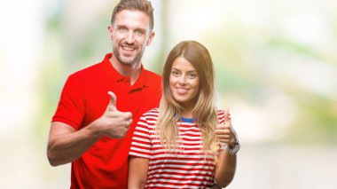 Genç çift hareketi el ile mutlu yaşasın yapıyor izole arka plan üzerinde aşık. Kameraya bakarak başarı gösteren ile ifade onaylama.