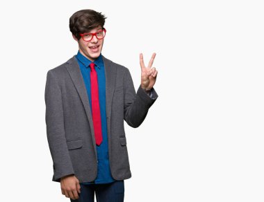 Mutlu yüz zafer işareti yaparken kameraya göz kırpıyor ile gülümseyen izole arka plan üzerinde kırmızı gözlük takan genç yakışıklı iş adamı. İki numaralı.