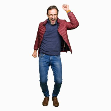 Hareketli rahat ve kendinden emin müzik gülümseyen gözlük ve mutlu ve neşeli, dans kış ceket giyen orta yaş yakışıklı adam